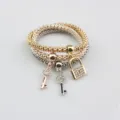 Set de pulseras elásticas de tres capas con candado y llaves brillantes de diamantes. - Set de tres piezas