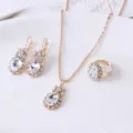 Gedetailleerd overzicht van gouden strass kristal sieradenset detail ketting oorbellen. - Wit