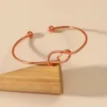 Minimalist rose gold tone open cuff bracelet with knot design, elegant adjustable wrist jewelry. - Rose Gold