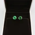 Close-up view of elegant round 8mm green zircon stud earrings displayed inside luxury jewelry box. - Silver + Green