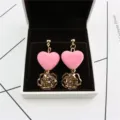 Sweet pink velvet heart and hollow rose crystal earrings detail shot in white jewelry box. - Pink