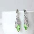 Gedetailleerd uitzicht op elegante zilveren oorbellen met strass-steentjes en groen kristal. - Stud oorbellen / Lichtgroen