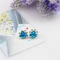 Blauwe roos strass oorknoppen detail close-up weergave, sprankelend kristallen bloemdesign. - Hemelsblauw