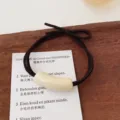 Minimalist brown hair tie with elegant ivory curved tube detail, perfect for daily chic style. - Cylinder / Beige