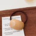 Minimalistische haarelastiek in melktheekleur, zoet en elegant haaraccessoire detail. - Ellips / Khaki