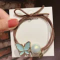 Elegant brown hair tie with blue butterfly and pearl charm on display card for daily hair styling. - Butterfly/Blue