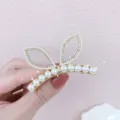 Gedetailleerd overzicht parel strass kattenoor haarspeld, elegante gouden haaraccessoire. - Konijnenoortje