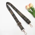 Vue détaillée de la bandoulière réglable avec motif géométrique tissé et crochets métalliques dorés. - Noir Base Kaki Foncé