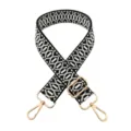 Detailed view of the black and white geometric jacquard replacement bag strap with gold metal hardware. - Black Light Grey