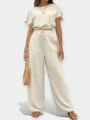 Detalle del conjunto de crop top y pantalón ancho beige con tela texturizada y corte elegante. - S / Parte Superior Y Inferior / Blanco Roto
