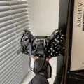 Zwarte laklederen schoudertas met polkadots, retro gesp en stijlvol trendy design. - Zwart