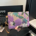Primo piano di un'elegante pochette ricamata con paillettes e delicati dettagli floreali. - Viola