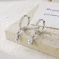 Elegant silver hoop earrings with moissanite pear-shaped drop and micro-pave stones - Pear Shape Moissanite Drop Style / Silver