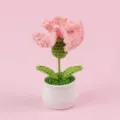 Detail van een handgehaakte roze anjer in een kleine witte pot - Roze