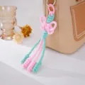 Geflochtener Schmetterlingsknoten-Taschenanhänger in Pastellrosa und Mint - Rosa
