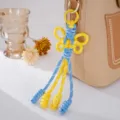 Handgefertigter gelb-blauer gewebter Schmetterlings-Taschenanhänger mit Quasten für Rucksäcke. - Gelb