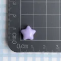 Detalle de un cabujón de resina de estrella púrpura en un tapete de medición de cm - Púrpura
