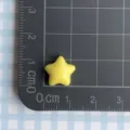 Yellow mini star resin accessory for DIY hair clips shown on a metric measurement mat - Yellow