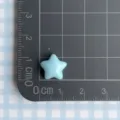 Detailed view of light blue star resin charm on a measuring mat for DIY crafts - Blue