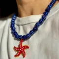 Gros plan d'un collier de perles rayées bleues avec pendentif étoile de mer rouge. - Collier Étoile de Mer Rouge Perles Bleues