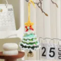 Handgefertigter grüner Häkel-Weihnachtsbaumschmuck mit gelbem Stern und goldener Glocke - Verschneiter Stil K / 1 Stück