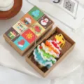 Handgehäkelte bunte Weihnachtsbaum-Plüschfigur in einer festlichen Kraft-Geschenkbox. - Verschneiter Stil M / Geschenkbox