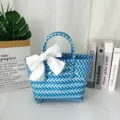 Detalle de un bolso tejido a mano en azul y blanco que incluye un elegante lazo blanco grande. - Mediano (Con Lazo Azul Claro) / Rayas Azules