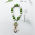 Grünes und weißes Silikon-Perlen-Schlüsselband mit Gänseblümchen-Anhänger - Grün mit Blume