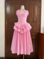 Elegant pink halter neck dress with boning and tiered ruffled skirt on mannequin. - Light Pink