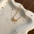 Elegante collar de acero de titanio dorado con colgantes de corazones huecos entrelazados - Dorado