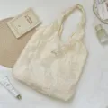 Macro view of French vintage floral embroidery and lace texture on a cream tote bag. - Hollow Rose Vest Bag / Off White