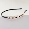 Gedetailleerd overzicht van de elegante zwarte haarband met sprankelende geometrische strass. - Diamant Haarband