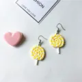 Detailed shot of cute yellow and white polymer clay lollipop earrings, playful style. - Ear Hooks 1 Pair / Yellow
