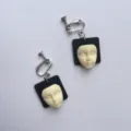 Handgemaakte retro eigenzinnige gezichtsoorbellen met zwarte houten basis en wit masker. - Zwarte oorclip