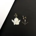 Vista detallada de pendientes de clip asimétricos con ángel y arco de estilo retro. - Ángel y Arco Asimétricos / Pendientes de clip estilo C