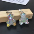 Cute handmade glitter bear resin clip-on earrings close-up detail showcasing colorful sequins. - Clip-On Earrings / White