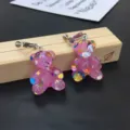 Cute pink resin bear earrings with colorful foil flakes, clip-on style jewelry detail shot. - Clip-On Earrings / Hot Pink