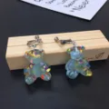 Handmade resin bear clip earrings with colorful iridescent flakes detail view for cute style. - Clip-On Earrings / Light Green