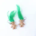 Primer plano de pendientes de muneco Troll retro con pelo verde y ganchos metalicos. - Pendientes de gancho verdes