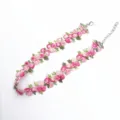 Vue détaillée du collier ras de cou en dentelle brodée de fleurs roses avec fermoir. - Rouge Prune