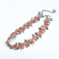Détail du collier ras de cou brodé de fleurs montrant des coutures délicates et une chaîne. - Rose foncé