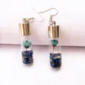 Close-up detail of blue dried flower glass vial earrings with silver plated hooks. - Blue