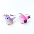 Close-up detail shot of cute chubby bird earrings featuring colorful resin little animals. - Earring Hooks / Purple Wine Red