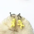 Detaillierte Nahaufnahme süßer gelber Babypuppen-Ohrclips mit kreativem tollem Design. - Schraub-Clip-Ohrringe / Gelb