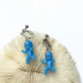 Nahaufnahme der blauen Babypuppen-Ohrclips mit süßen Mini-Anhänger und praktischem Schraubverschluss. - Schraub-Clip-Ohrringe / Blau