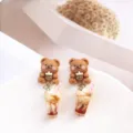 Gros plan détaillé de boucles d'oreilles mignonnes ours et thé au lait, style doux. - Ours Marron Café