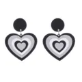 Détail en gros plan de boucles d'oreilles cœur en acrylique noir et blanc avec design scintillant. - Boucle Noire Paillettes Dégradé Cœur Superposé (Style 3)