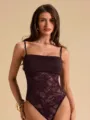Close-up detail view of sexy purple lace patchwork strappy bodysuit, premium fabric style. - Fuschia