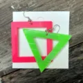 Neon acryl geometrische oirringen detail met levendig roze vierkant en groene driehoek. - Vierkant en driehoek / Rozerood en Groen