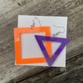Close-up van geometrische neon acryl oorbellen met oranje vierkant en paarse driehoek. - Vierkant en driehoek / Oranje En Paars